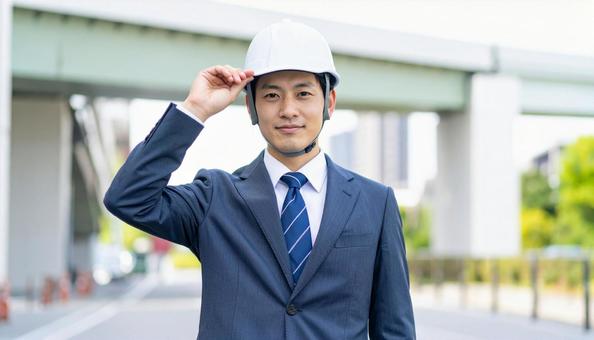頭にかぶったヘルメットを触るビジネスマン 頭にかぶったヘルメットを触るビジネスマンの写真
