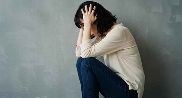 頭を抱える女性　悩むの写真