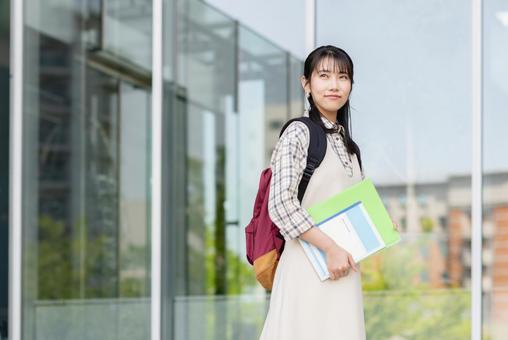 キャンパスを歩く女子大学生 キャンパスを歩く女子大学生の写真