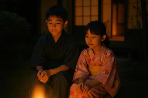 夜の庭で光を見る姉弟 夜の庭で光を見る姉弟の写真