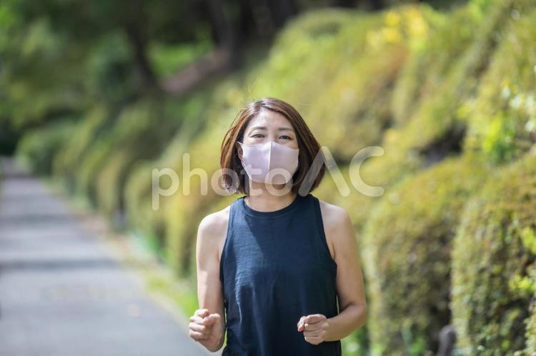ジョギング・ランニング・ウォーキングする女性（マスク） 運動,有酸素運動,ランニングの写真素材