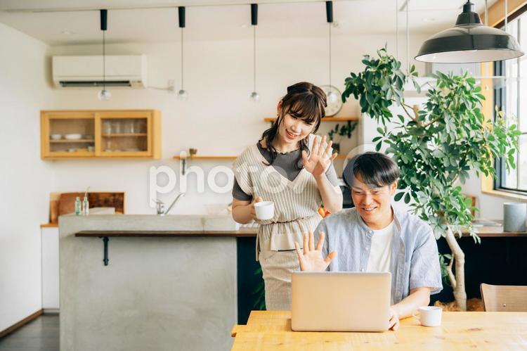 家でパソコンを使う男女（ビデオ通話） ビデオ通話,パソコン,夫婦の写真素材
