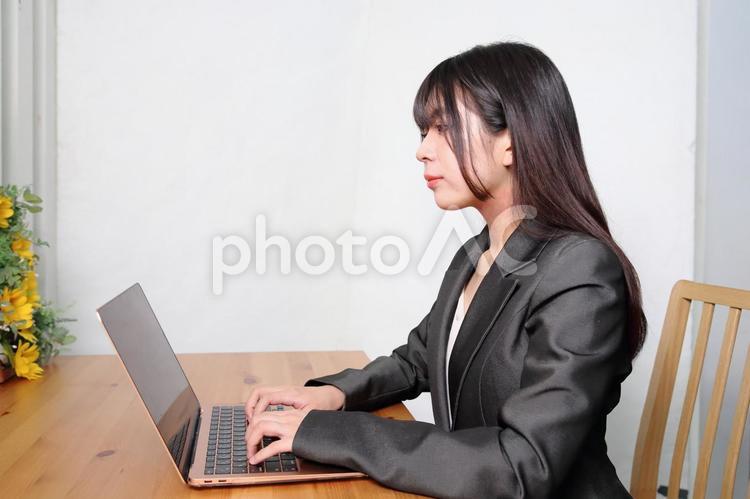 パソコンを操作するノマドワーカーの女性 女性,パンツスーツ,人物の写真素材