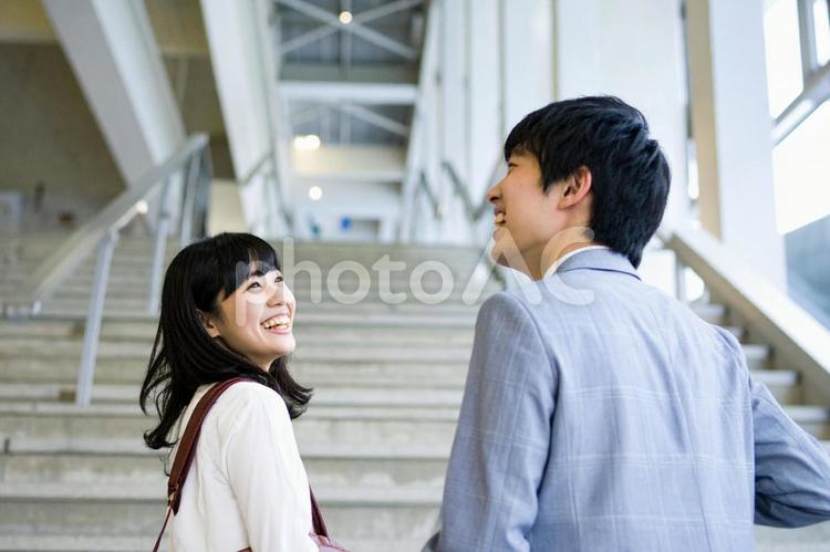 階段の手前で楽しそうに会話する男女 日本人,男性,女性の写真素材