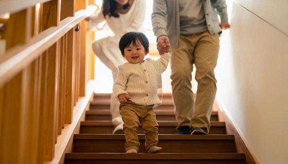 階段を下りるのが楽しい子供と見守る両親 階段を下りるのが楽しい子供と見守る両親の写真