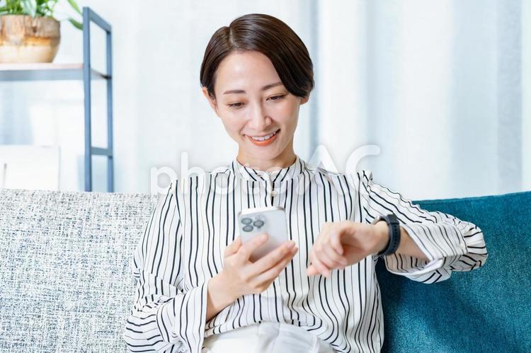 時計を持ちスマートウォッチをつける女性 ヘルスケア,スマートウォッチ,社会人の写真素材