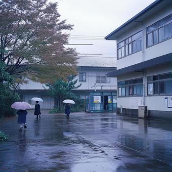 傘を差す学生たちと雨に濡れる校庭の風景 傘を差す学生たちと雨に濡れる校庭の風景の写真