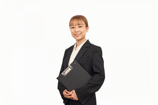 資料を持ったビジネススーツの女性 資料を持ったビジネススーツの女性 受付,ネームプレート,案内の写真素材