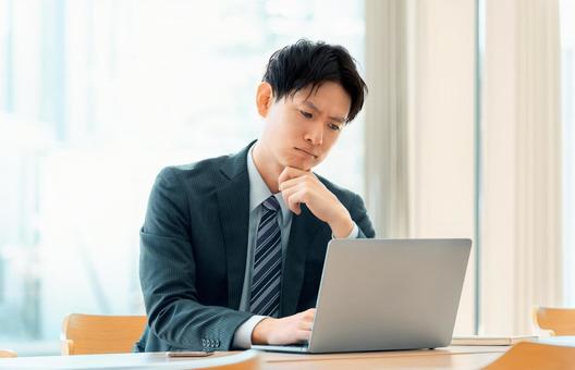 パソコンを使いながら悩む男性ビジネスマン パソコンを使いながら悩む男性ビジネスマン 男性,パソコン,悩むの写真素材