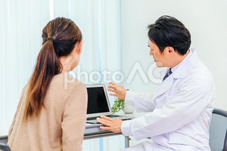 診察する男性医師と女性患者（ノートパソコン） 人間ドック,健康診断,婦人科検診の写真素材
