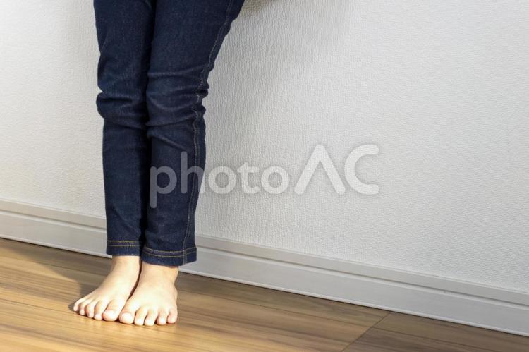 壁際に立っている女の子の脚（4歳、顔無 足,子供,足元の写真素材