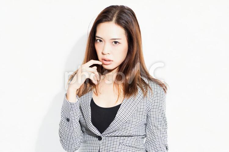 白い背景の前に立ってポーズをとる若いビジネスウーマン 女性,白背景,立つの写真素材