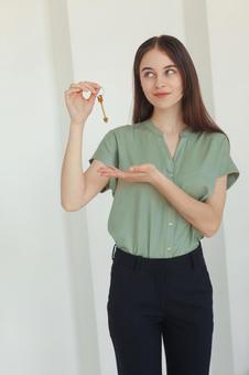 鍵を見て笑みを浮かべる女性スタッフ 保険業,事務職,接客業の写真素材