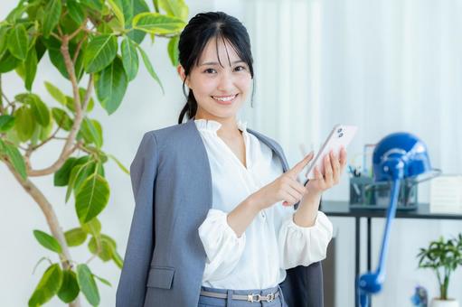スマホを操作するビジネスウーマン ビジネスウーマン,スマホ,笑顔の写真素材
