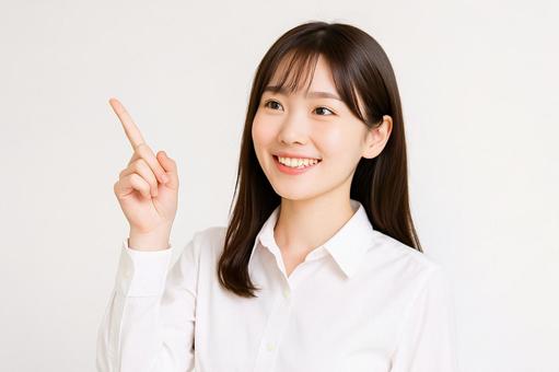 白背景で上方指差す女性 白背景で上方指差す女性の写真