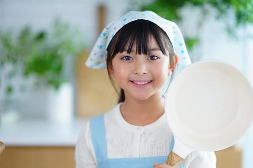 料理を始める前にポーズをとる少女 女の子,フライパン,持つの写真素材