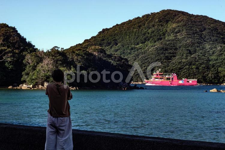 ＜素材＞観光地で船の写真を撮る女性 女性,人物,風景の写真素材