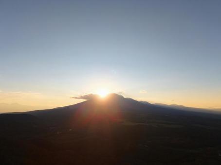 山の端にかかる太陽の写真