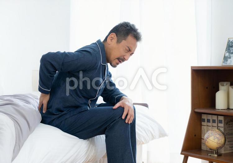 朝起きたら体調の悪いミドルの男性 男性,ミドル,腰痛の写真素材