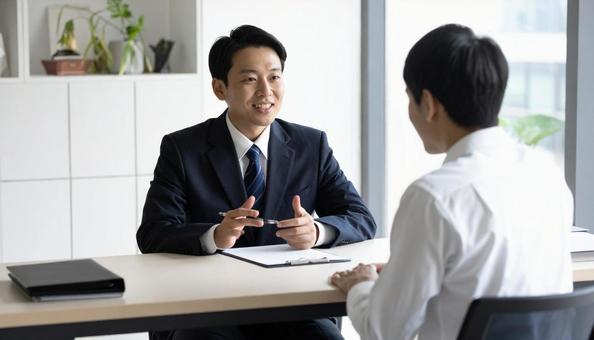 オフィスで面談する日本人ビジネスパーソンの写真