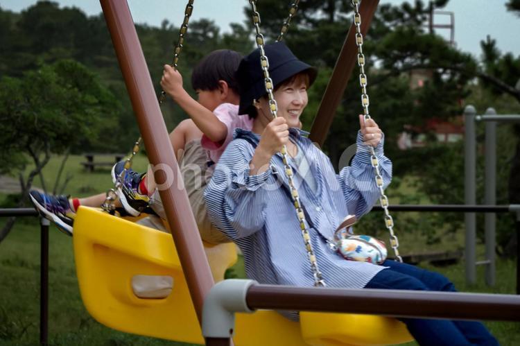R＜素材＞夏の公園でブランコで遊ぶ親子 家族,親子,笑顔の写真素材