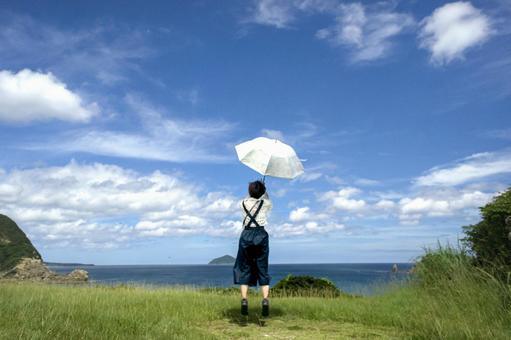 <素材>夏の海を眺める日傘の女性と青空 <素材>夏の海を眺める日傘の女性と青空 女性,人物,風景の写真素材