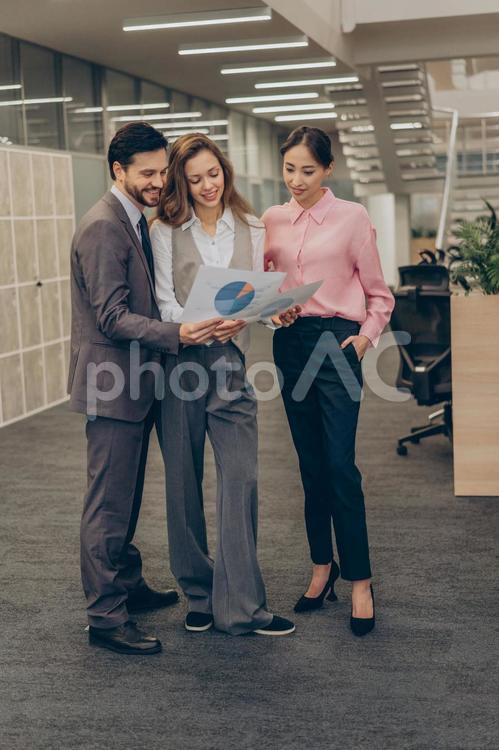 オフィスで立ったまま打ち合わせしている男女 コワーキング,ビジネス,女性の写真素材