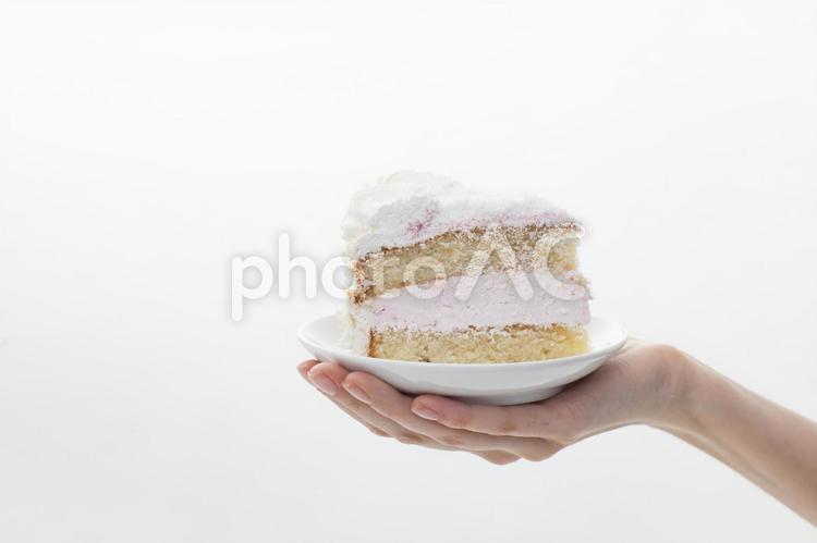 お皿にのったケーキを持っている人の手元 手元,白,ケーキの写真素材