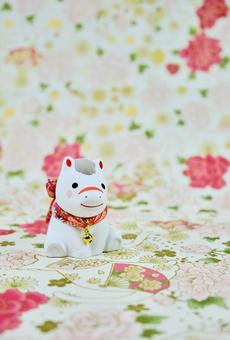 可愛い馬の置物と和柄の背景の年賀状素材の写真