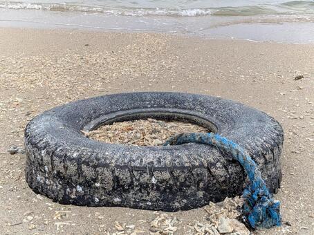 漂着物：タイヤと青いロープ タイヤ,海,砂浜の写真素材