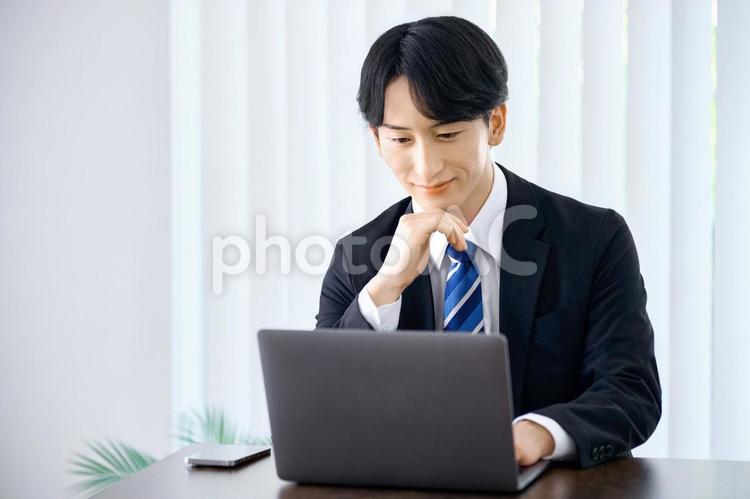 ノートパソコンを使うビジネスマン　若い　 ビジネスマン,デスクワーク,ノートパソコンの写真素材