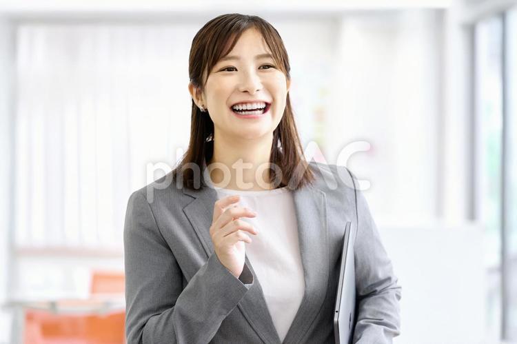 歩くビジネスウーマン　オフィス ビジネスウーマン,笑顔,ノートパソコンの写真素材