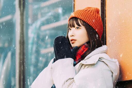 雪の降る冬の街角に立つ女性 冬,雪,女性の写真素材