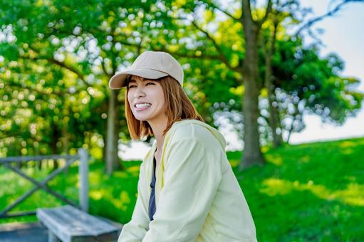 散歩中にベンチに座って休憩する女性 散歩中にベンチに座って休憩する女性 休憩,休む,ベンチの写真素材