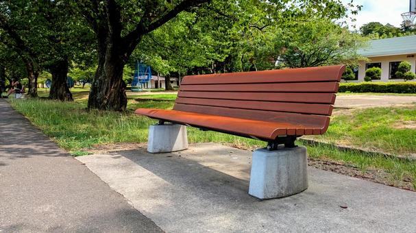 木陰にある公園のベンチ 木陰にある公園のベンチの写真