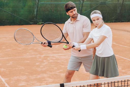 白いシャツの女性とピンクのシャツの男性の指導シーン 男女,外国人,テニスの写真素材