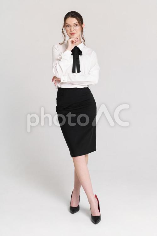 微笑み足をクロスしてポーズする若い外国人女性 女性,立つ,クロスの写真素材