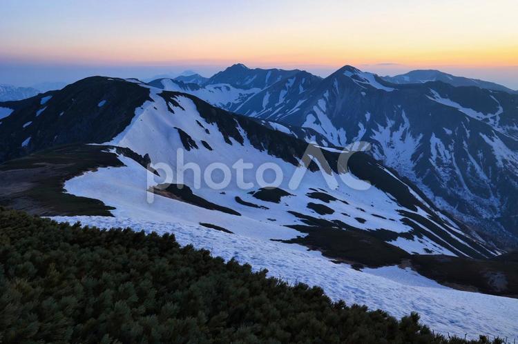 朝焼けの冠雪の北アルプスの稜線 北アルプス,朝焼け,モルゲンロートの写真素材