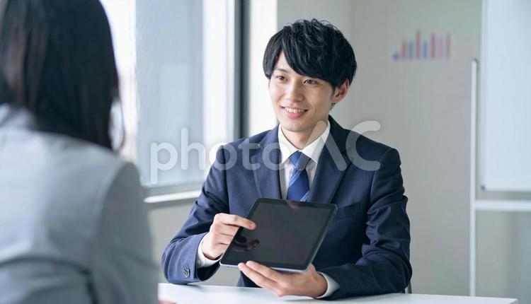 タブレットを使って説明する男性営業マン タブレット,男性営業マン,男性ビジネスマンの写真素材
