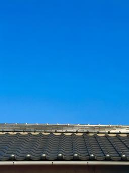 屋根瓦と雲一つない青空がさわやかに(縦) 屋根瓦と雲一つない青空がさわやかに(縦)の写真