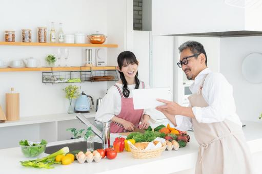 キッチンで料理を作るミドルの夫婦 キッチンで料理を作るミドルの夫婦 料理,夫婦,家族の写真素材