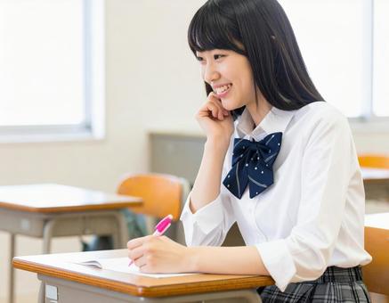 授業中に笑顔を見せる女子高生 授業中に笑顔を見せる女子高生の写真