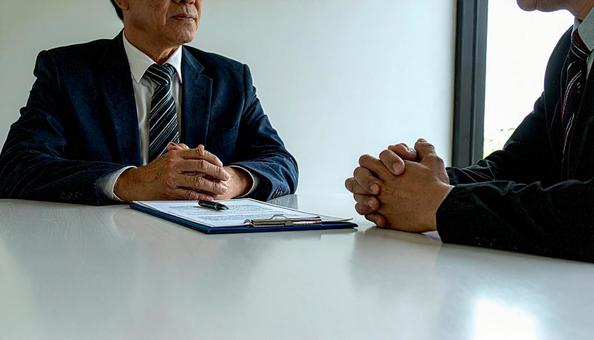 打ち合わせに臨む二人のビジネスマンの写真