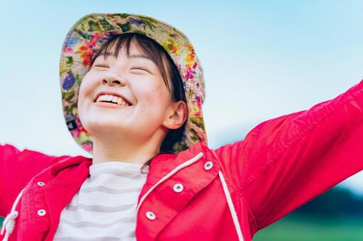 草原でリラックスした表情の女性  女性,笑顔,充実の写真素材