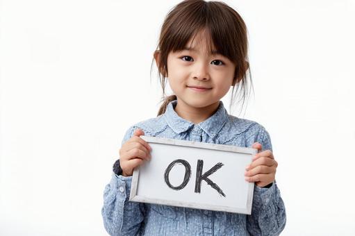 OKと書いたボードを見せる子供 OKと書いたボードを見せる子供の写真