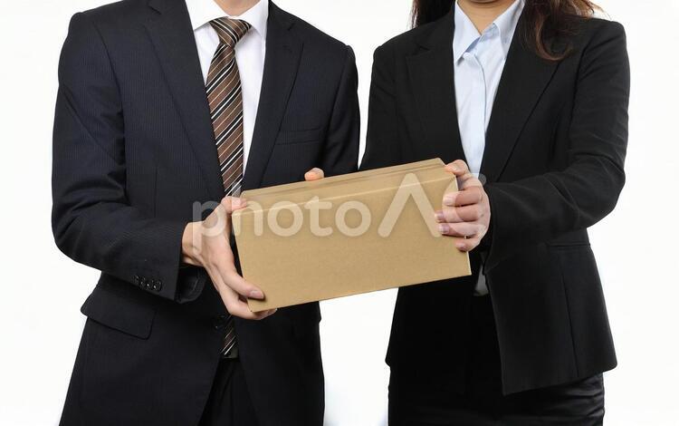 荷物を持っているビジネスマン男女 2人,お届け,カップルの写真素材