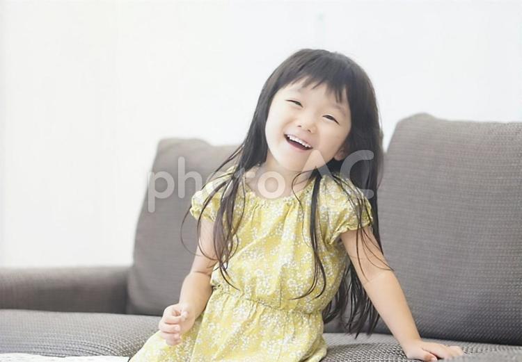 ソファーに座った笑顔の女の子 笑顔,女の子,子供の写真素材