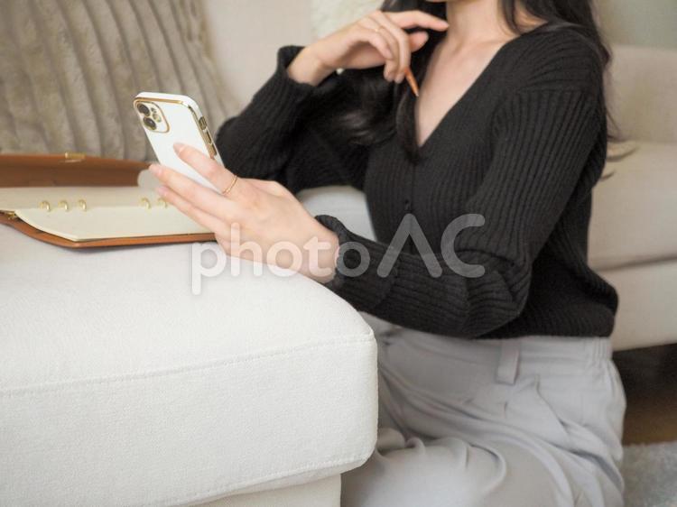 スマートフォンを見ながら考える女性 女性,スマホ,スマートフォンの写真素材