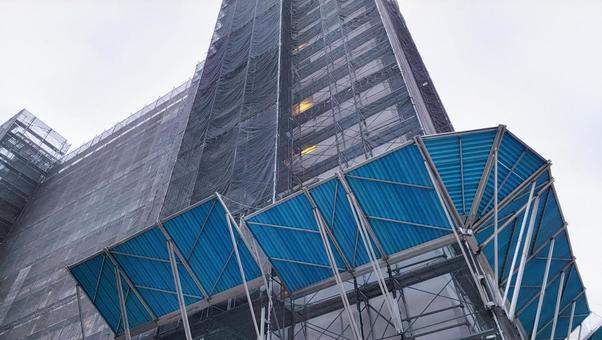 足場と防護ネットで覆われた建物 足場と防護ネットで覆われた建物 マンション,建物,工事の写真素材