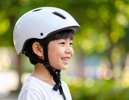 自転車用ヘルメットをかぶる男の子 自転車用ヘルメットをかぶる男の子の写真